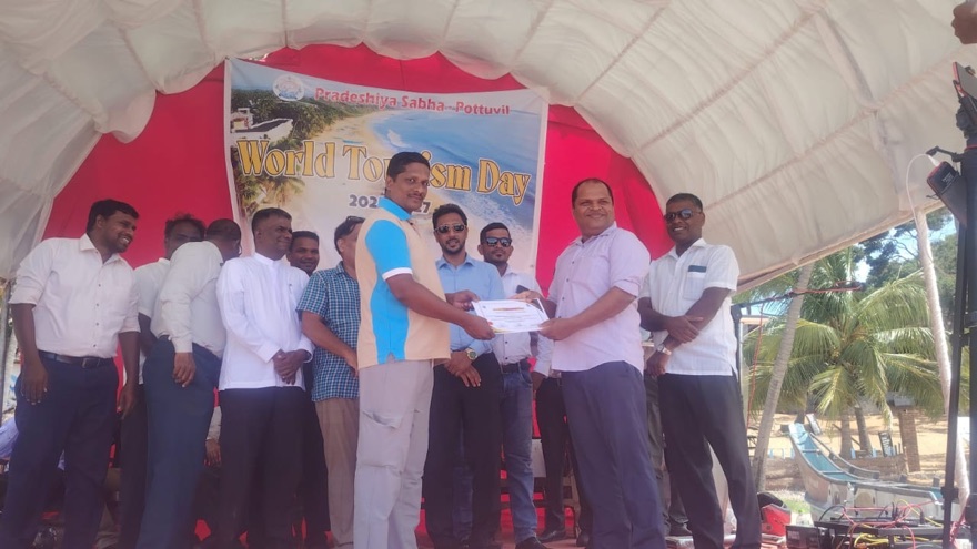 Mubarak recevant le prix du meilleur prestataire de services de transport sur scène lors du World Tourism Day 2025 à Arugam Bay